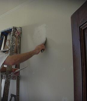 Man Preparing A Wall For Interior Painting