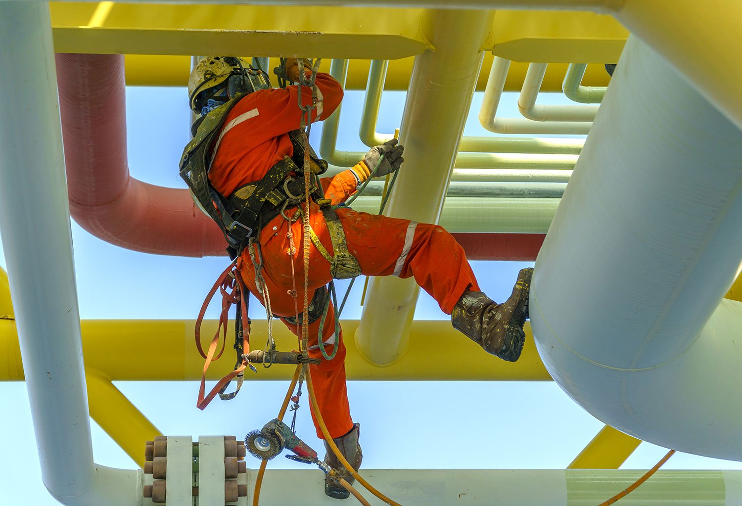 Industrial painter working on pipes